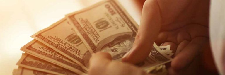 Someone counting out dollar bills.